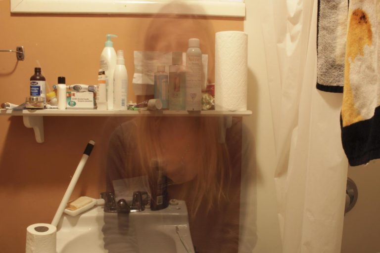 image of a bathroom full of chemicals with the ghost image of a woman