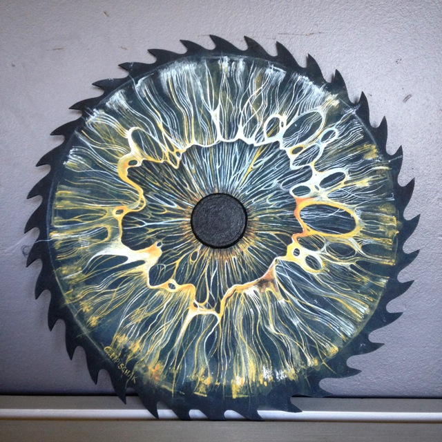 painting of an eye on a metal saw blade